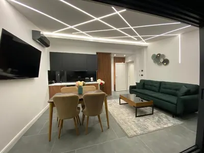 a living room with a table and a green couch at Apartments Dzaleta in Sveti Stefan