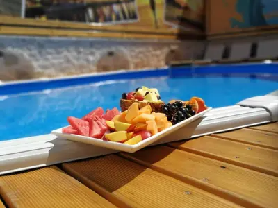 a plate of fruit next to a swimming pool at Apartments Dzaleta in Sveti Stefan