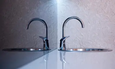 two sinks in a bathroom with chrome faucets at Apartments Dzaleta in Sveti Stefan
