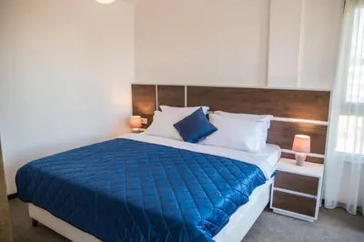 a bedroom with a bed with a blue comforter at Boutique Hotel 