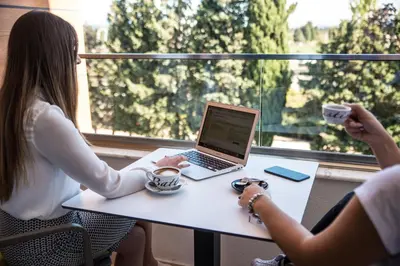two women sitting at a table with a laptop at Boutique Hotel 
