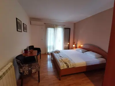 a bedroom with a bed and a table and a chair at Guesthouse Vukasevic in Virpazar