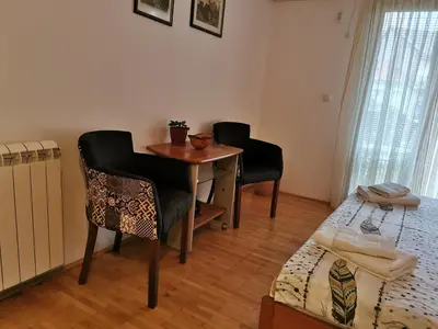 a room with a desk and chairs and a bed at Guesthouse Vukasevic in Virpazar