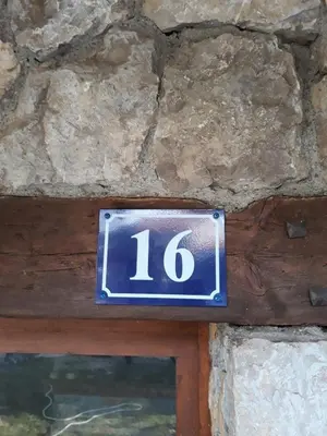 a blue sign with the number on a stone wall at Guesthouse Vukasevic in Virpazar