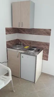 a small kitchen with a sink and a refrigerator at Apartmani 