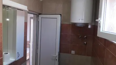a bathroom with a white door and a window at Apartmani 