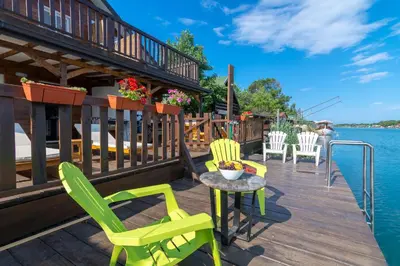 a deck with chairs and a table on the water at Hakuna Matata Apartments in Ulcinj