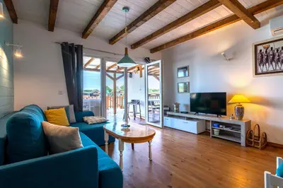 a living room with a blue couch and a tv at Hakuna Matata Apartments in Ulcinj