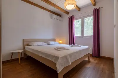a bedroom with a large bed with purple curtains at Hakuna Matata Apartments in Ulcinj