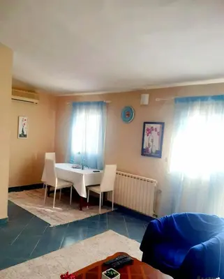 a living room with a table and chairs and curtains at Apartment Podgorica centre in Podgorica