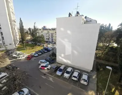 a parking lot with cars parked in front of a building at Apartment Podgorica centre in Podgorica