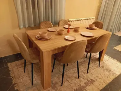 a wooden table with chairs and cups and plates on it at Apartment Podgorica centre in Podgorica