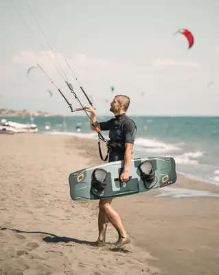 a man on the beach holding a kite board at Sea Star Apartments in Ulcinj