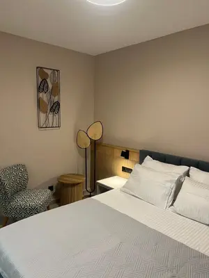 a bedroom with a white bed and a chair at Sea Star Apartments in Ulcinj