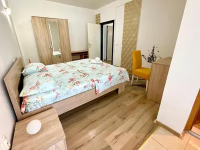 a small bedroom with a bed and a chair at Apartments Flamingo in Ulcinj