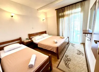 a hotel room with two beds and a window at Apartments Flamingo in Ulcinj
