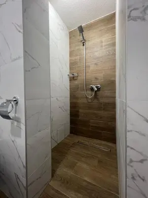a bathroom with a shower with a glass door at Azzure Apartment in Ulcinj