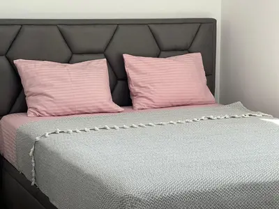 a bed with two pink pillows on top of it at Azzure Apartment in Ulcinj