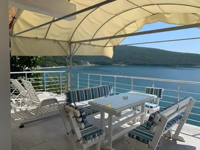 a patio with a table and chairs and an umbrella at Azzure Apartment in Ulcinj