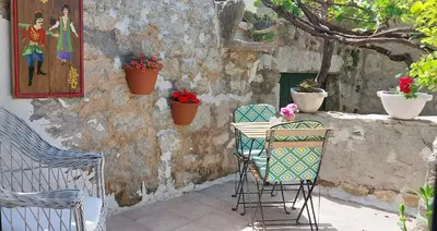 a patio with two chairs and a table with flowers at Boutique Home Saltaragazza in Petrovac na Moru