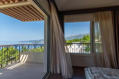 a bedroom with a view of a balcony at Luxury Villa Crystal Blue in Sveti Stefan