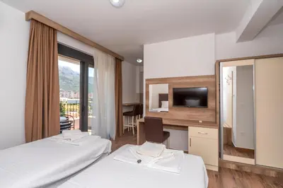 a hotel room with two beds and a television at Hotel Pharos in Bar