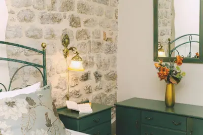 a bedroom with a bed and a table with a lamp at D & Sons Apartments in Kotor