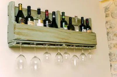 a bunch of wine bottles and glasses on a wall at D & Sons Apartments in Kotor