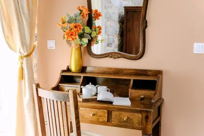 a table with a mirror and a vase with flowers at D & Sons Apartments in Kotor