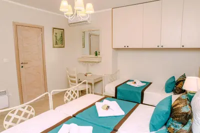 a room with two beds and a table at D & Sons Apartments in Kotor
