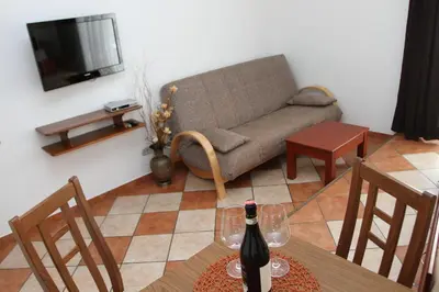 a living room with a couch and a table with a bottle of wine at Adriatic Apartment in Ulcinj