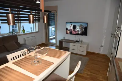 a kitchen and living room with a table and a couch at Apartment Lux Fontana in Budva