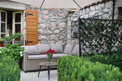 a patio with a couch and a table with a vase of flowers at Apartman L&M in Cetinje