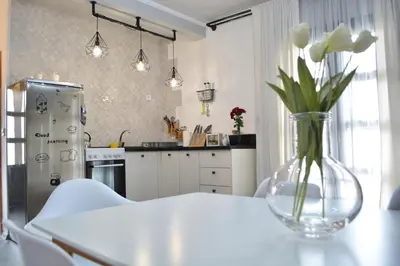 a kitchen with a vase of flowers on a table at Apartman L&M in Cetinje