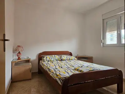 a small bedroom with a bed and a window at Apartmani Vujicic in Bar