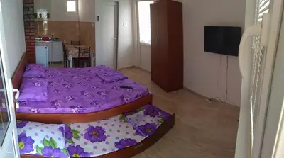 a bedroom with a purple bed in a room at Apartmani Vujicic in Bar