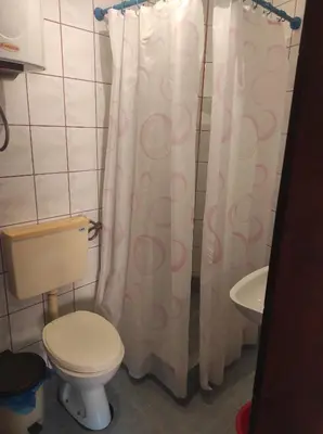 a bathroom with a toilet and a shower curtain at Apartmani Vujicic in Bar