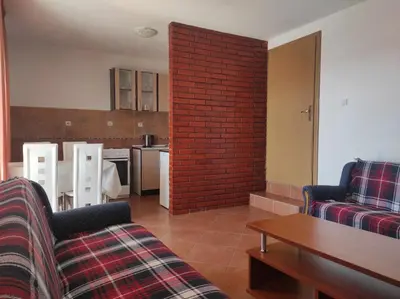 a living room with two couches and a brick wall at Apartmani Vujicic in Bar