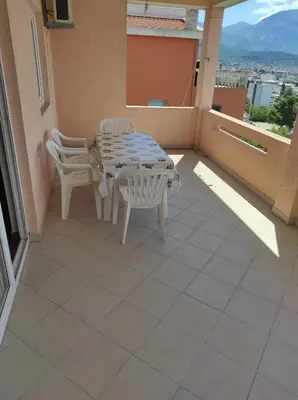 a patio with a table and chairs on a balcony at Apartmani Vujicic in Bar
