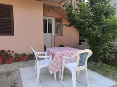 a table with two chairs and a tablecloth on a patio at Apartmani Vujicic in Bar