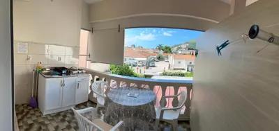 a small kitchen with a table and a balcony at Apartments Batalo in Budva