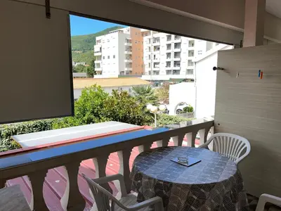 a table and chairs on a balcony with a window at Apartments Batalo in Budva