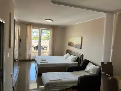 a hotel room with two beds and a couch at Apartments Batalo in Budva
