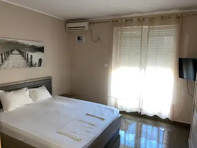 a bedroom with a large bed and a window at Apartments Batalo in Budva