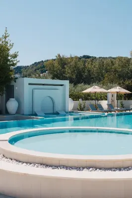 a swimming pool in a resort with chairs and umbrellas at Apartments Stanaj in Ulcinj