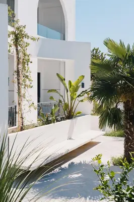 a white house with palm trees in front of it at Apartments Stanaj in Ulcinj