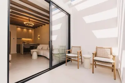 a room with glass doors and chairs and a bedroom at Apartments Stanaj in Ulcinj