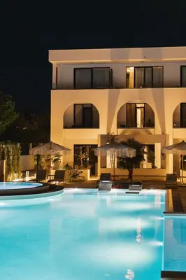 a large swimming pool in front of a building at night at Apartments Stanaj in Ulcinj