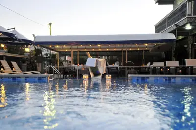 a swimming pool with a table and chairs in a building at Aparthotel Villa Primafila in Ulcinj