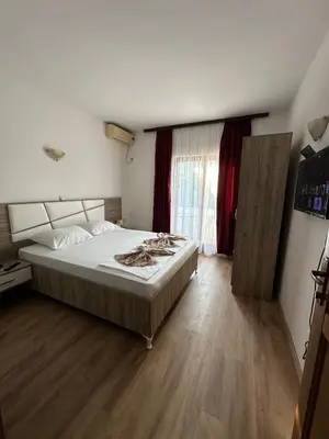 a bedroom with a large bed and a window at Rooms Ajllin in Ulcinj